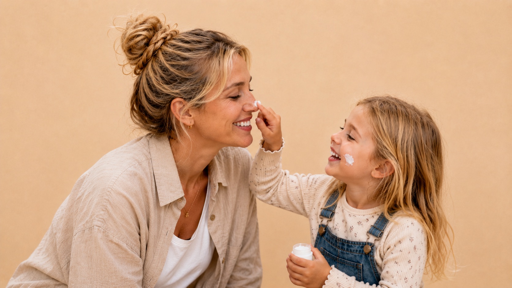 Mädchen tupft der lachenden Mutter Creme auf die Nase