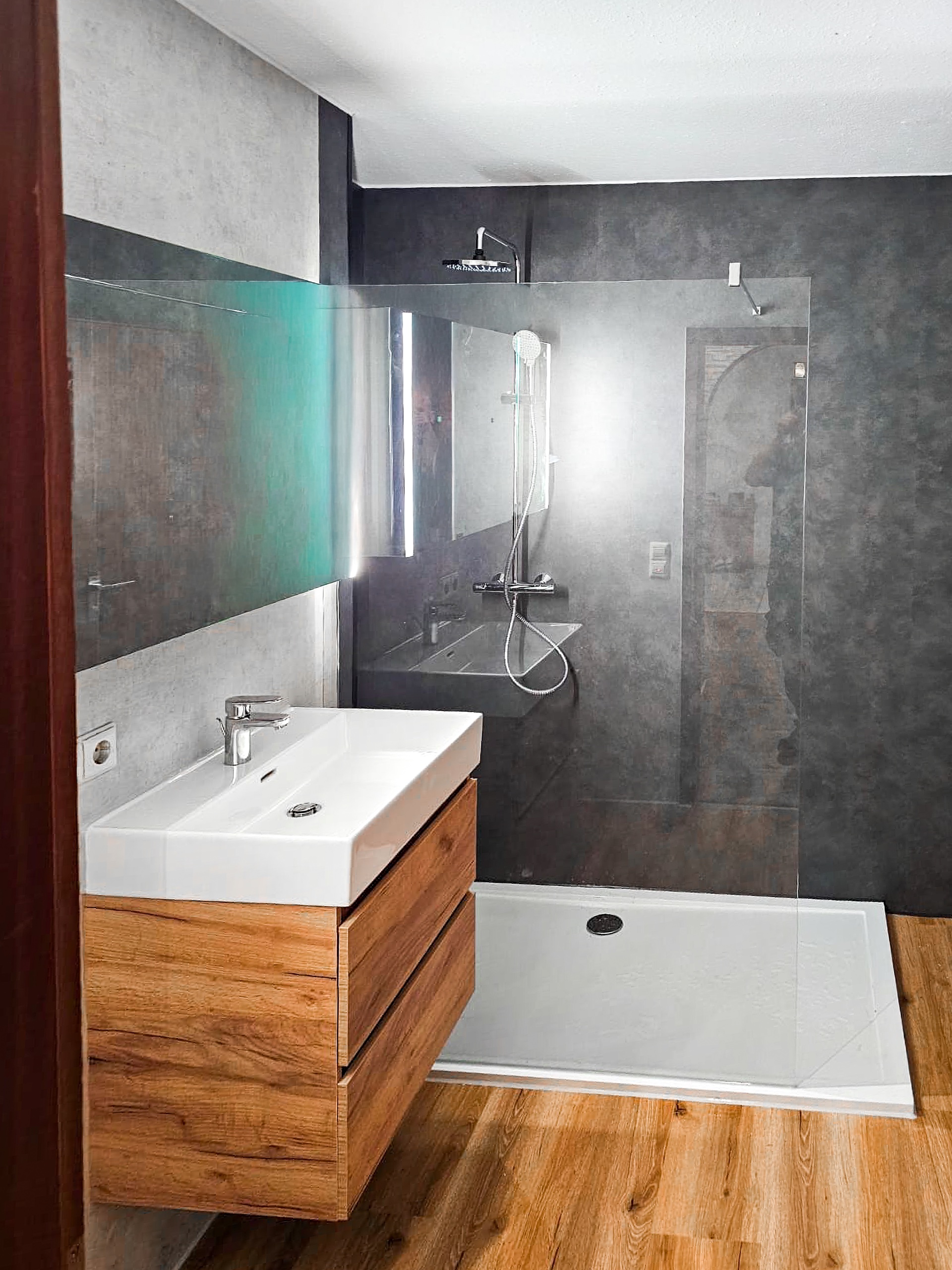 Walk-In-Dusche mit dunklen Wandpaneelen und Regendusche